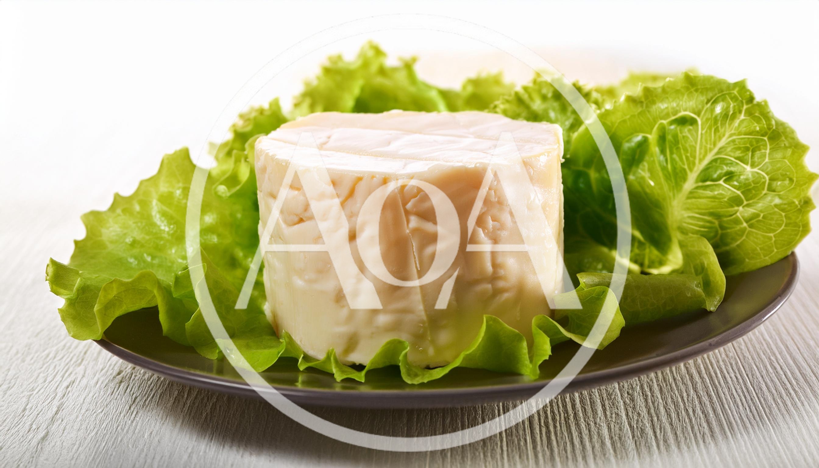 Fresh Round Cheese Wheel Served On Lettuce Leaves