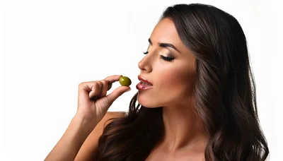 Beautiful Woman Holding A Green Olive Near Her Lips