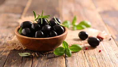Black Olives in a Wooden Bowl with Herbs