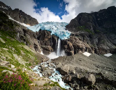 Glacier Waterfall Flowing Down Rugged Mountain Landscape