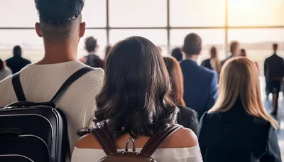 Diverse Travelers Waiting In Airport Terminal Departure Lounge