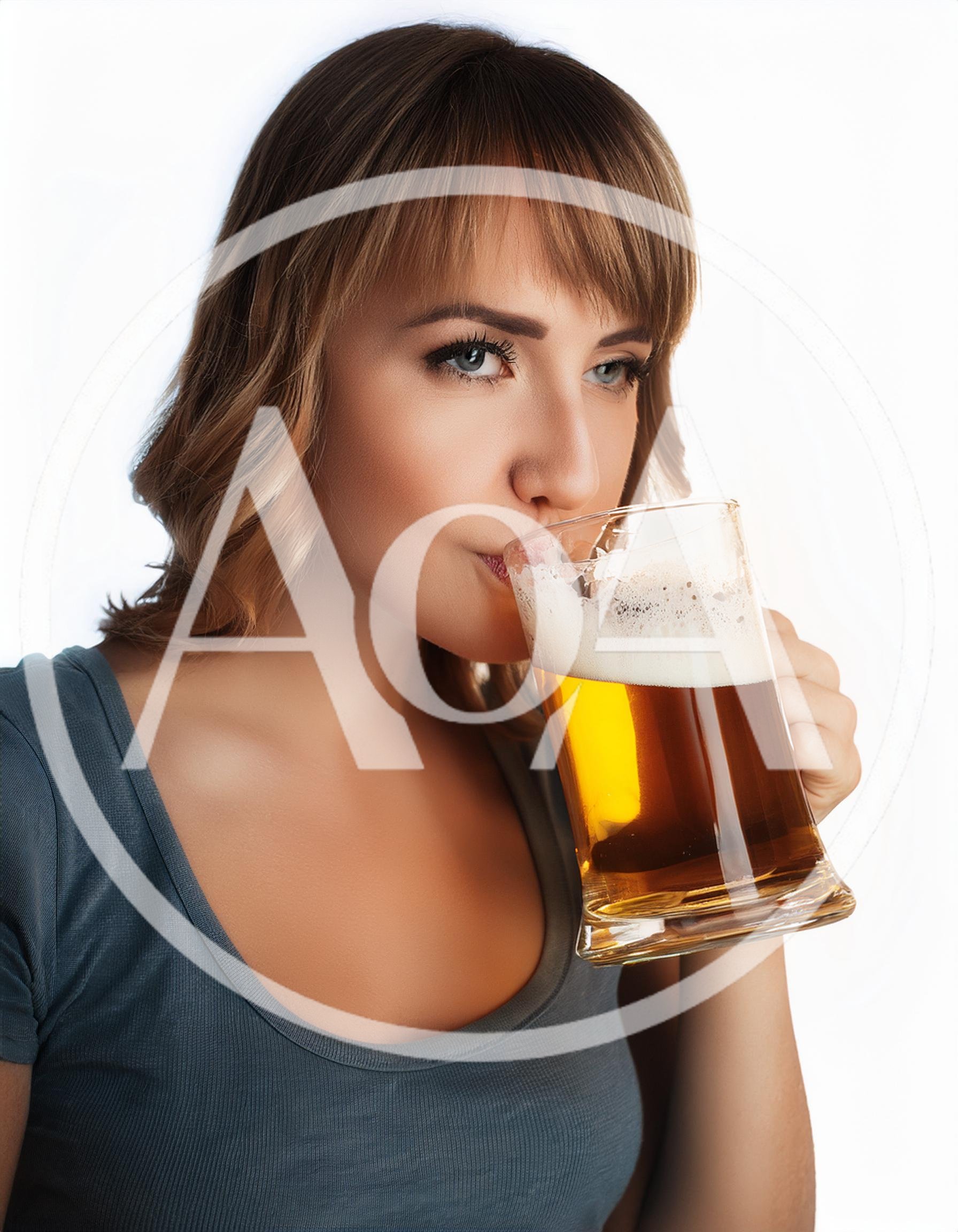 Young Woman Drinking Beer From A Glass Mug