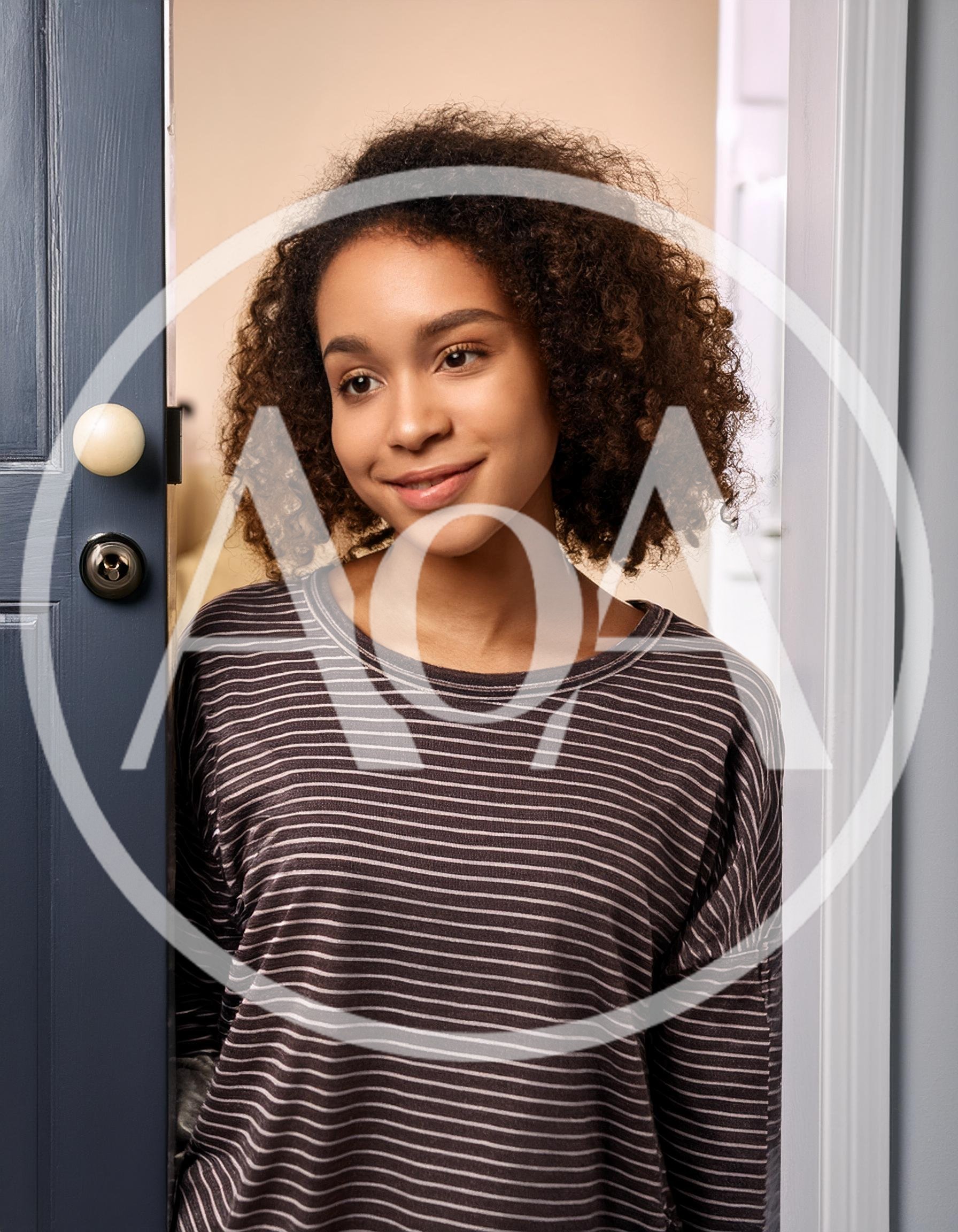 Young Woman Opening A Door To Welcome Guests