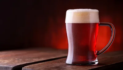 Glass Mug Of Dark Red Beer On Wooden Table