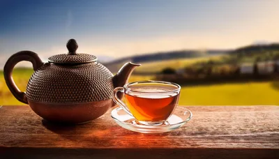 Cast Iron Teapot And Glass Cup On Wooden Table