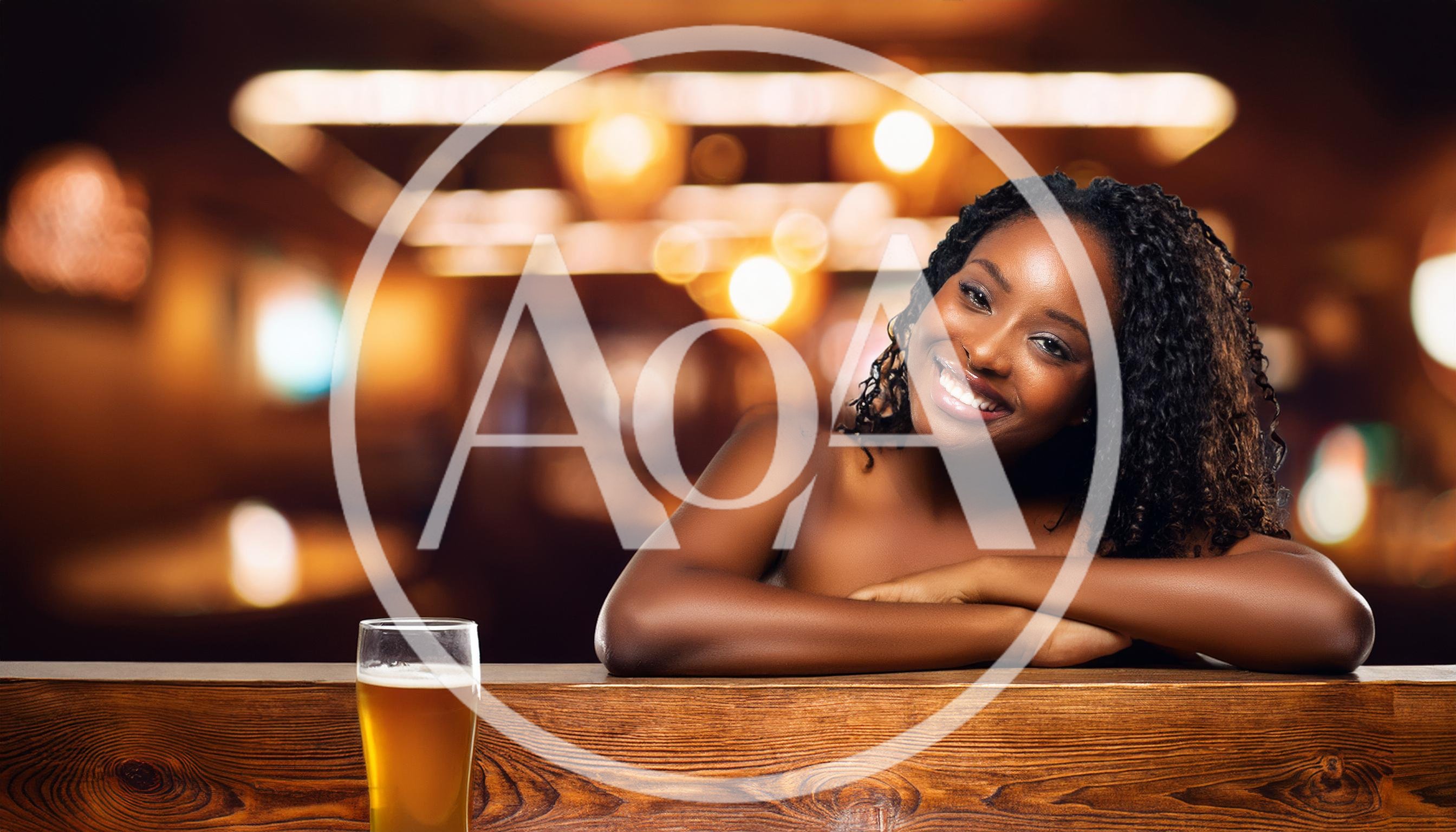 Smiling Woman Leaning On A Bar Counter With Beer