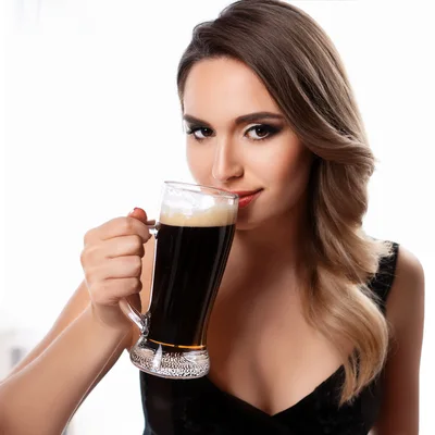 Beautiful Woman Drinking Dark Beer From A Glass Mug