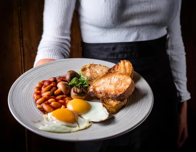 Waitress Serving A Traditional English Breakfast Plate