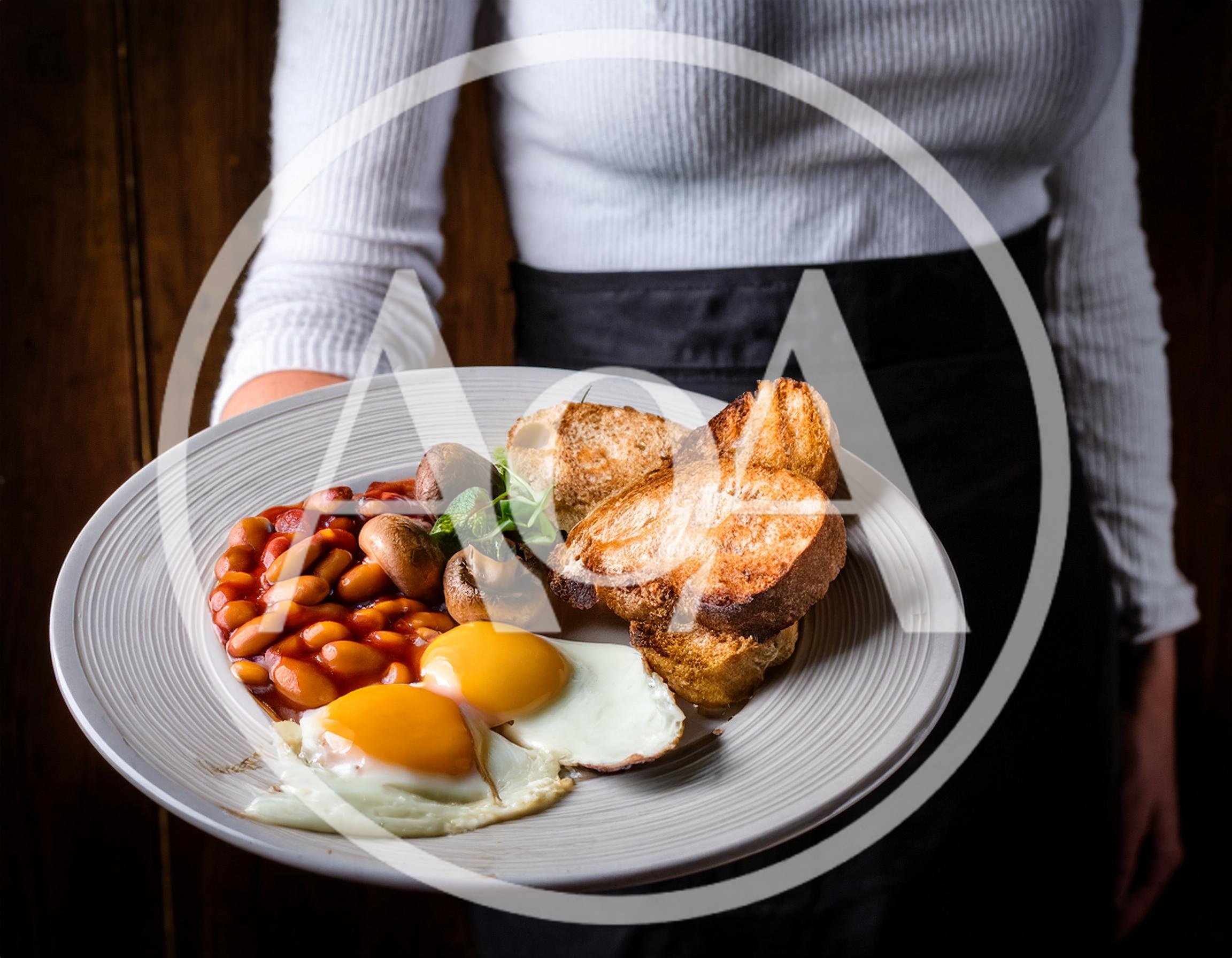 Waitress Serving A Traditional English Breakfast Plate