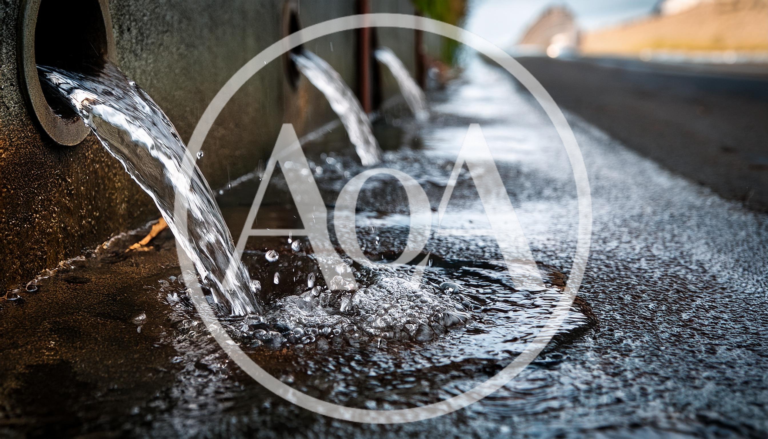 Water Flowing From Concrete Drainage Pipes Into Gutter