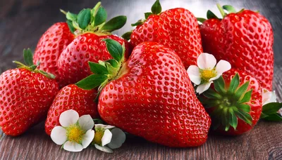 Fresh Ripe Strawberries With Blossoms On Wooden Surface