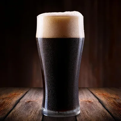 Cold Glass Of Dark Stout Beer On Wooden Table