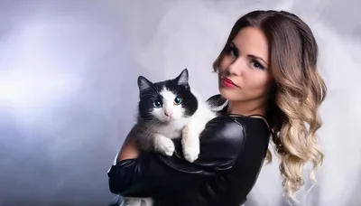 Young Woman Holding A Black And White Cat