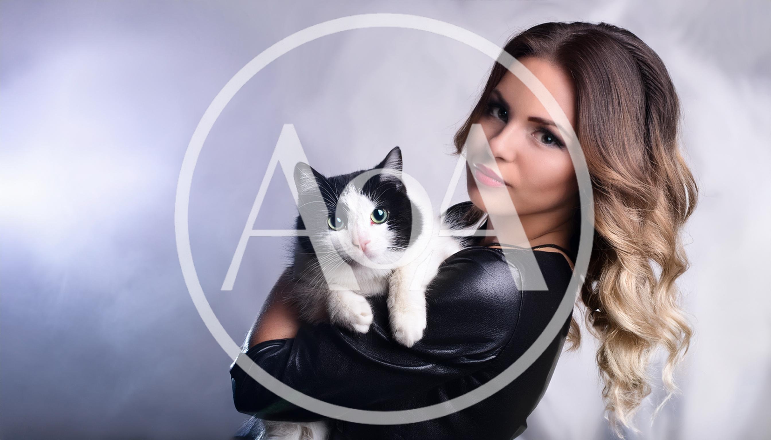 Young Woman Holding A Black And White Cat