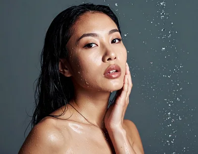 Young Asian Woman With Wet Skin Under Water Spray