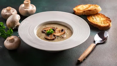 Creamy Mushroom Soup Served In A White Bowl