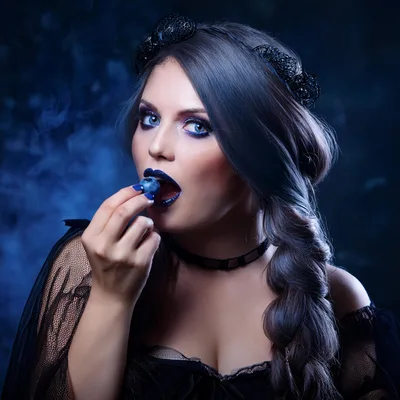 Gothic Woman Eating A Blueberry In Dark Studio