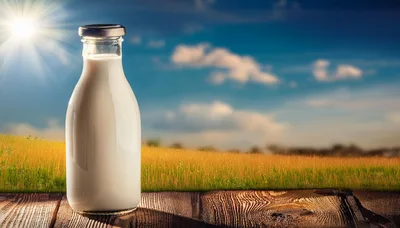 Glass Bottle Of Fresh Milk On Wooden Table