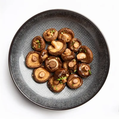 Roasted Shiitake Mushrooms On A Dark Textured Plate