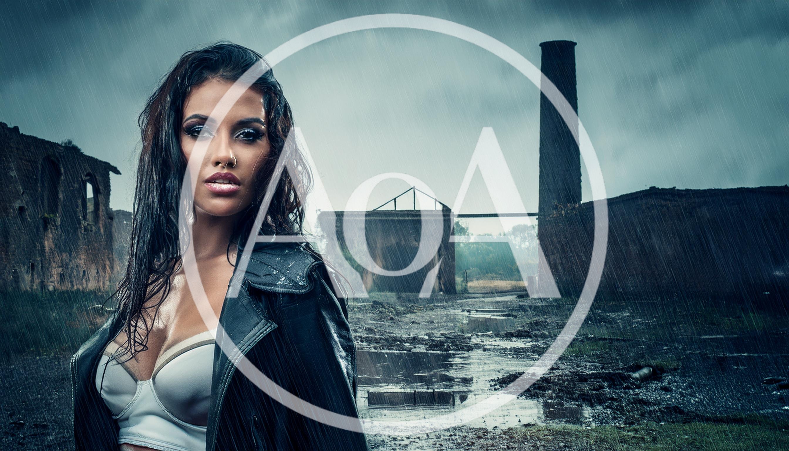 Fashionable Woman Standing In Rain At Abandoned Industrial Site