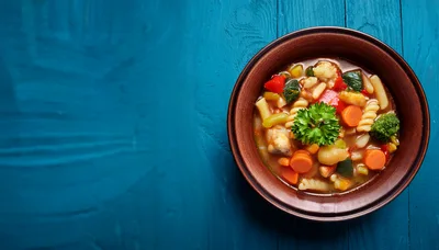 Bowl Of Vegetable Soup With Pasta On Blue Wood