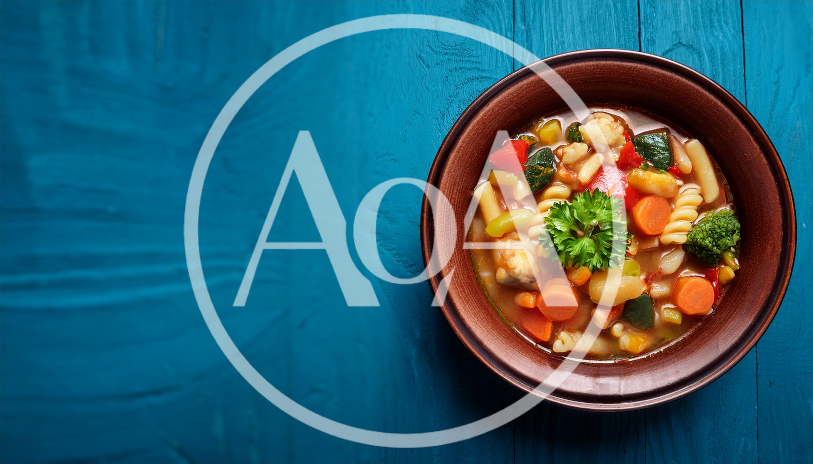 Bowl Of Vegetable Soup With Pasta On Blue Wood