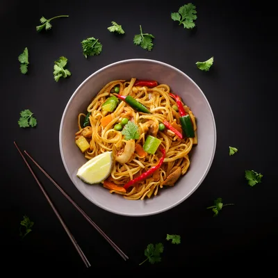 Bowl Of Pad Thai Noodles With Vegetables And Lime