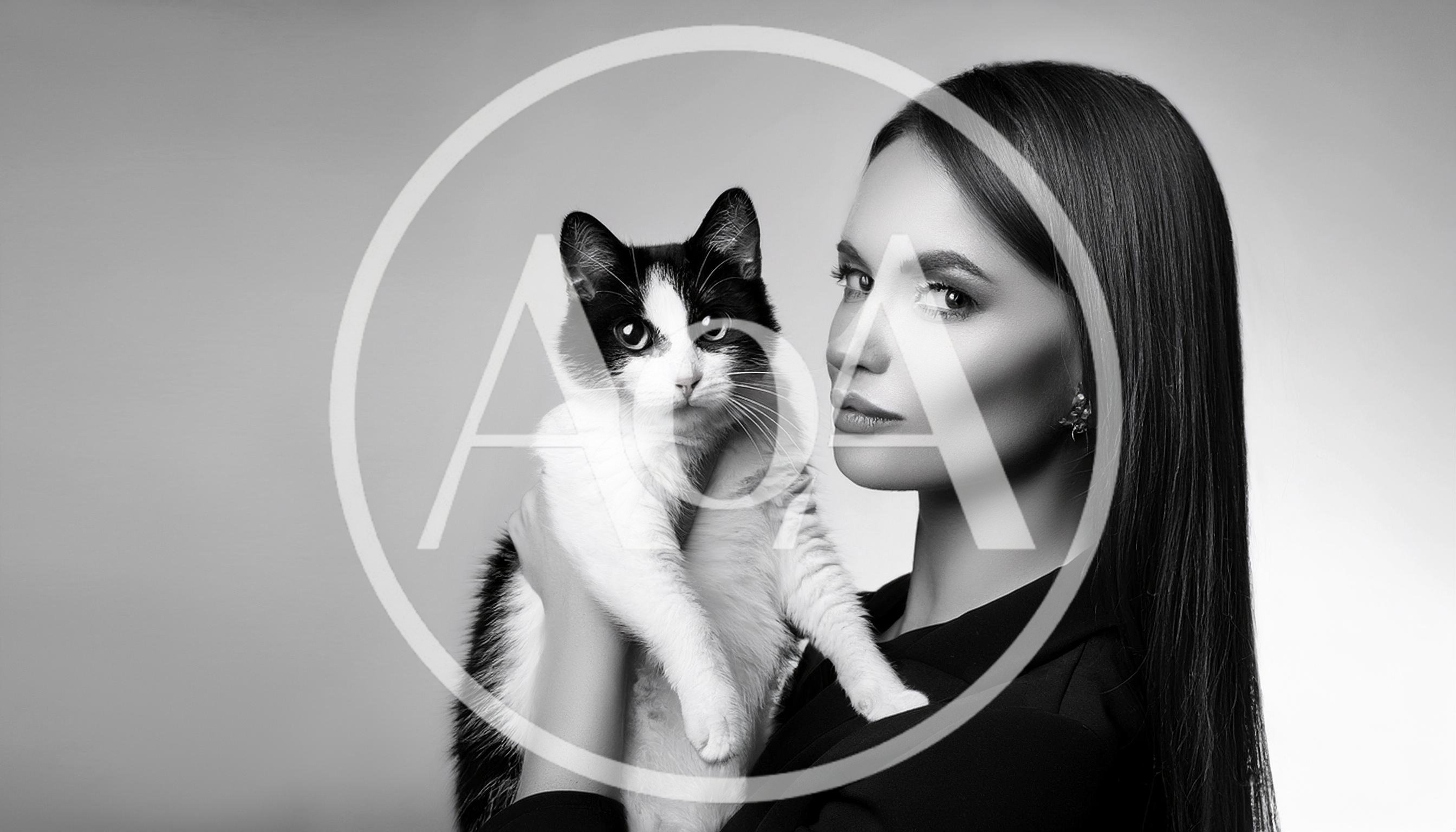 Elegant Woman Holding A Black And White Cat