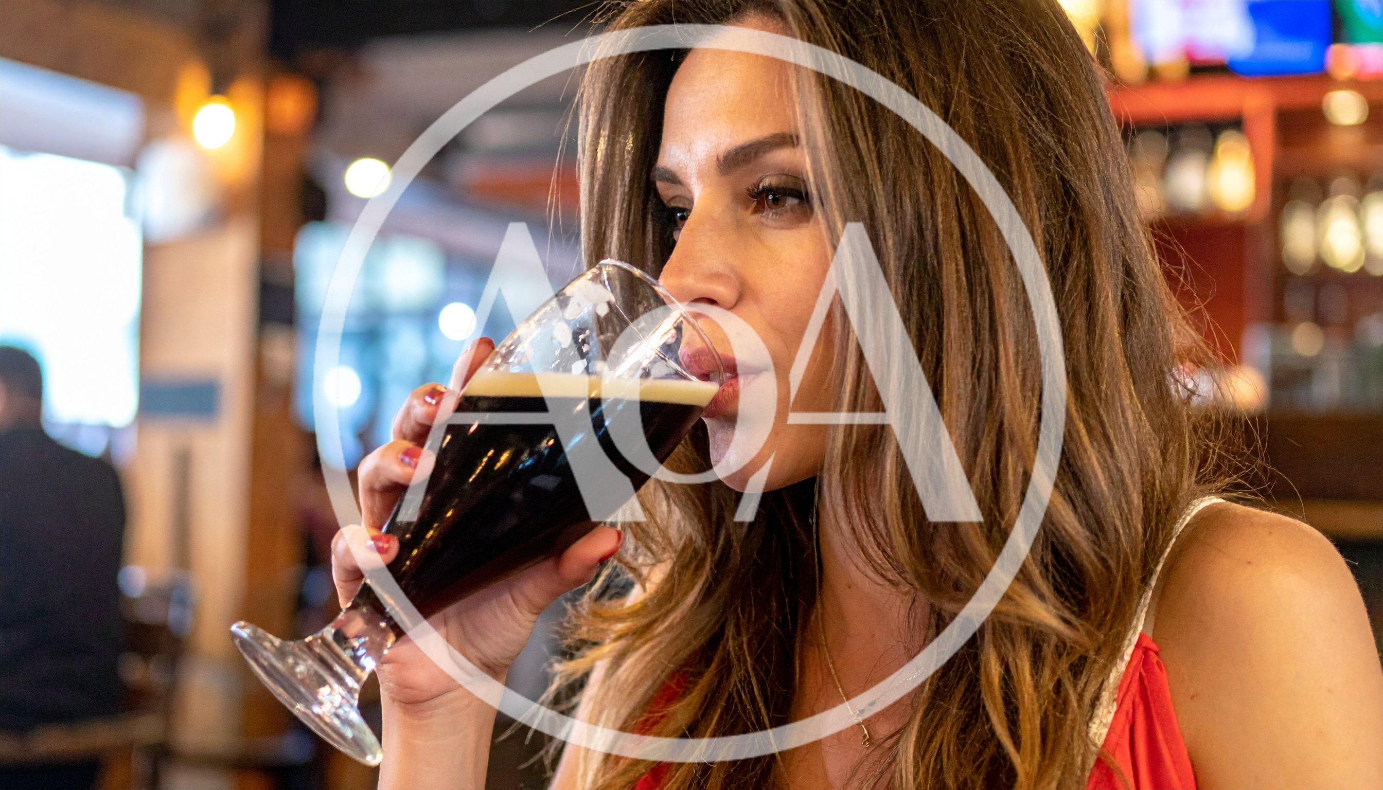 Woman Drinking Dark Beer In A Restaurant