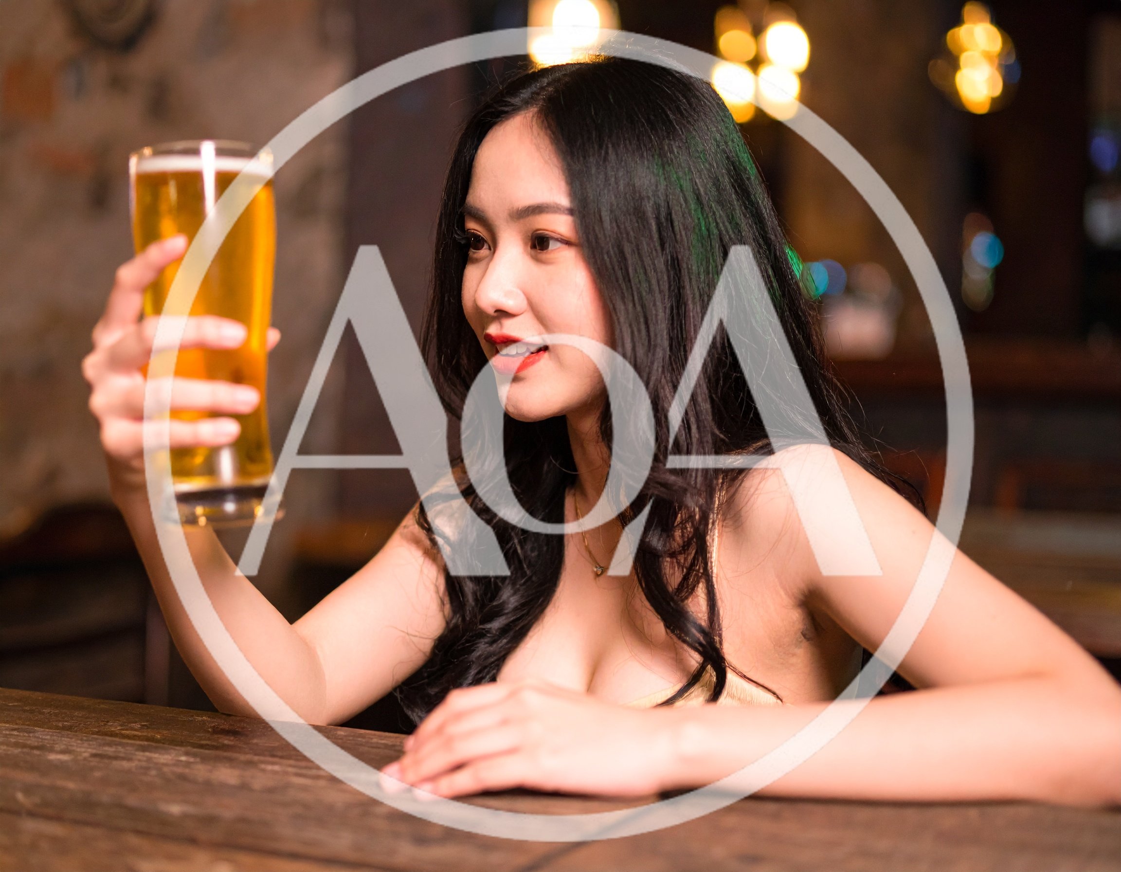 Young Woman Holding A Glass Of Beer In A Bar