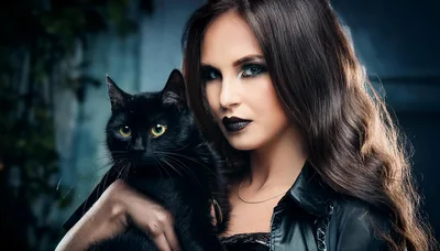 Woman With Dark Makeup Holding A Black Cat