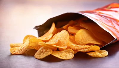 Potato Chips Spilling From An Open Snack Bag