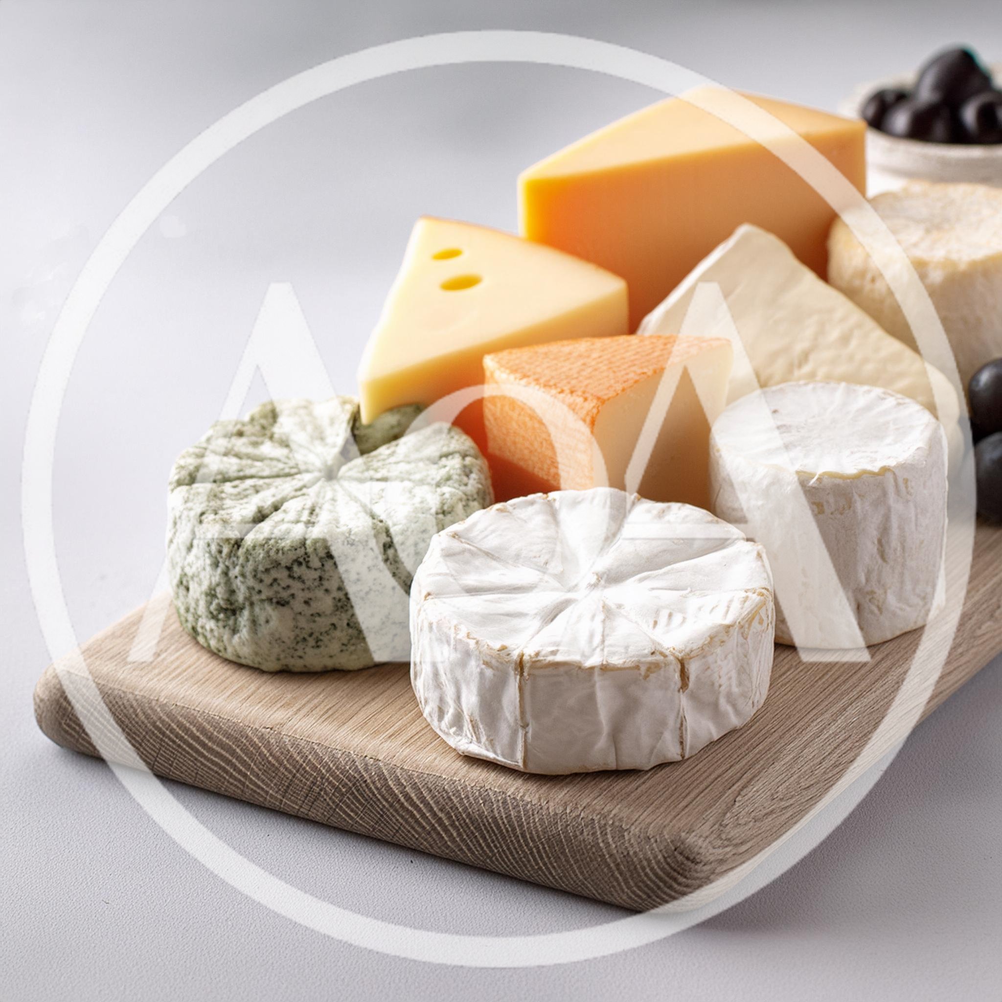 Assorted Gourmet Cheeses Arranged On A Wooden Board