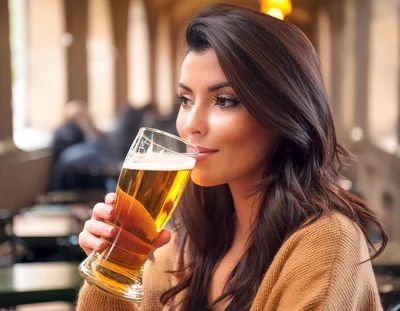 Young Woman Drinking Beer at an Outdoor Cafe
