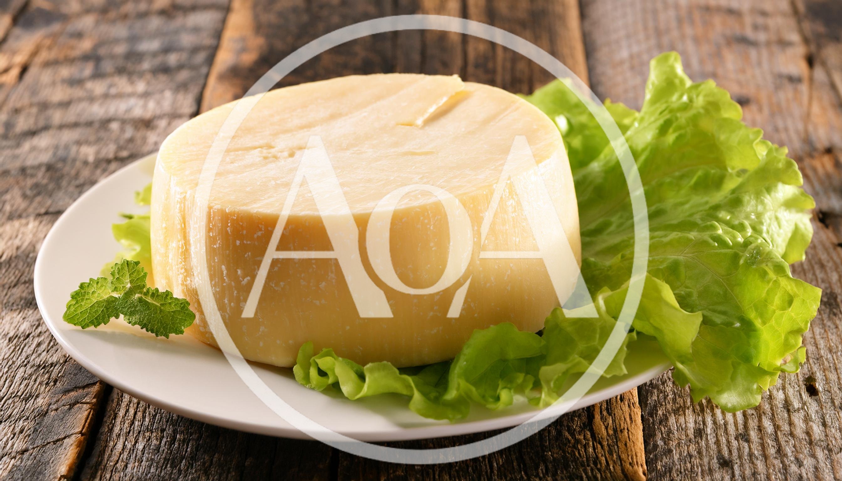Round Wheel Of Cheese On A Plate With Lettuce