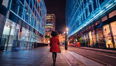 Woman In Red Coat Walking Through Modern City Street