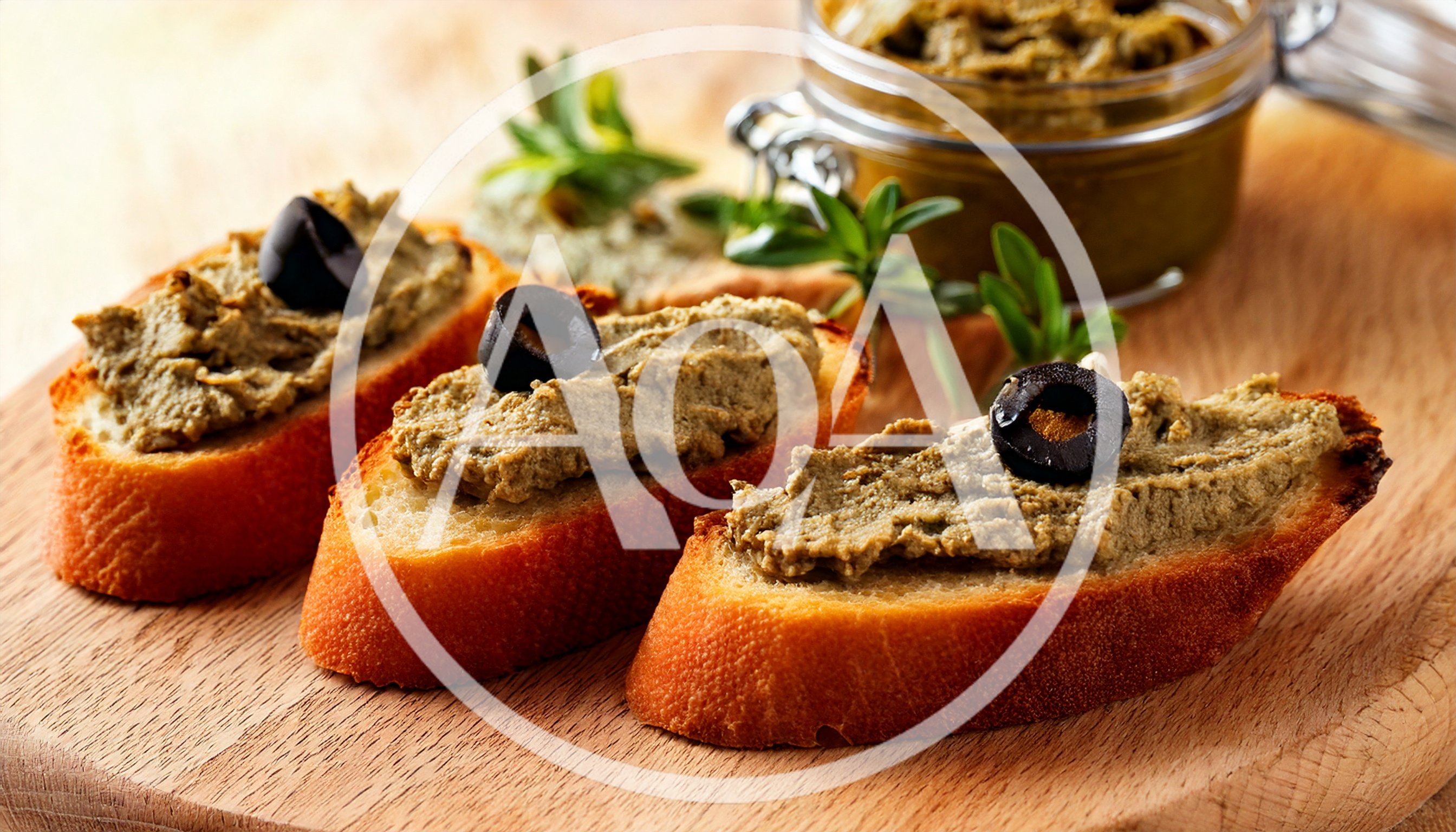 Three Toasted Baguette Slices Topped With Olive Tapenade