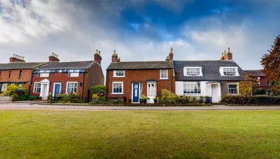 Row Of Traditional English Brick Cottages Facing A Green