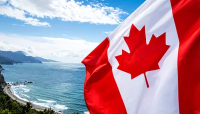Canadian Flag Waving Over Coastal Landscape