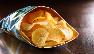 Open Bag Of Crispy Potato Chips On Wooden Table