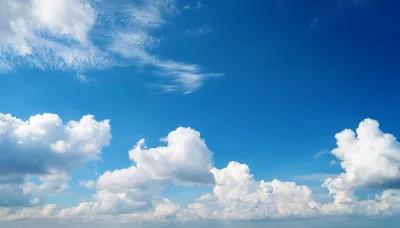 Fluffy White Cumulus Clouds Against A Deep Blue Sky