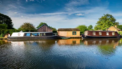 Narrowboats Moored Along A Peaceful Canal Bank