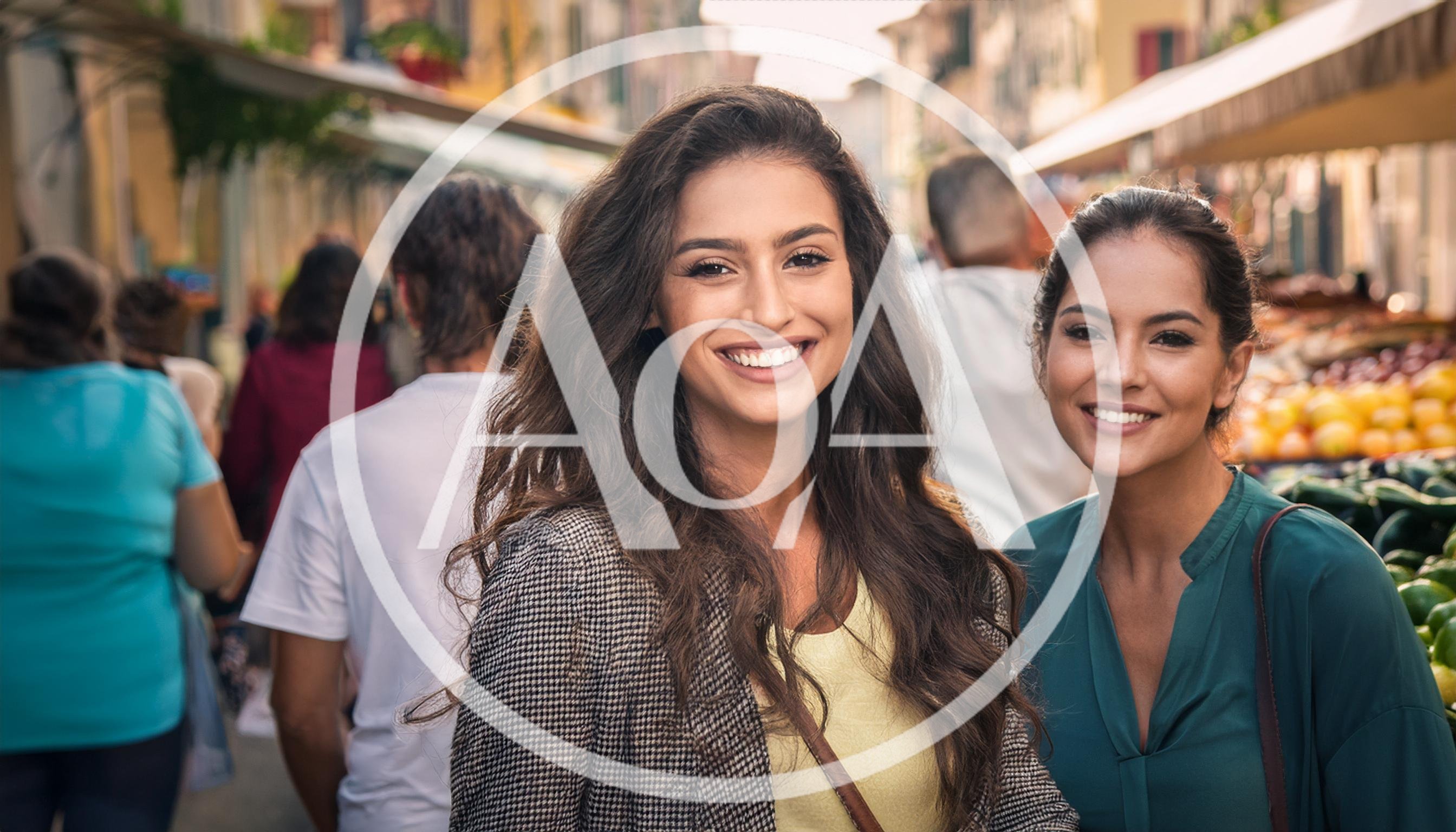 Two Young Women Smiling At A Busy Outdoor Market