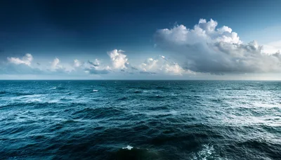 Deep Blue Ocean Waves Under A Dramatic Cloudy Sky