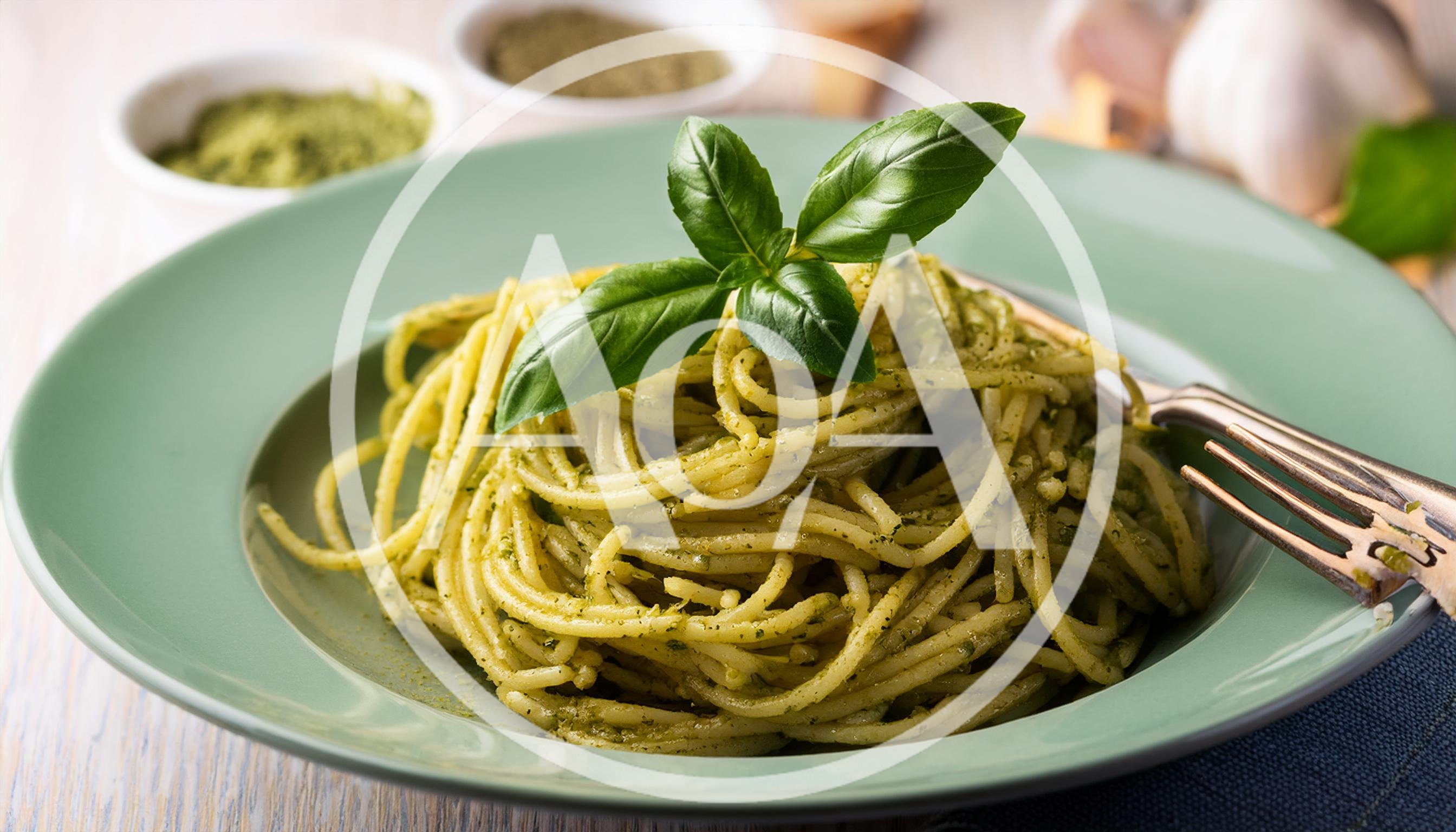 Spaghetti With Pesto Sauce On A Green Plate