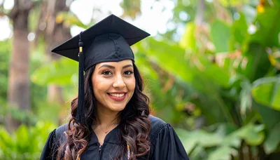 Young Woman Wearing Graduation Cap and Gown Outdoors