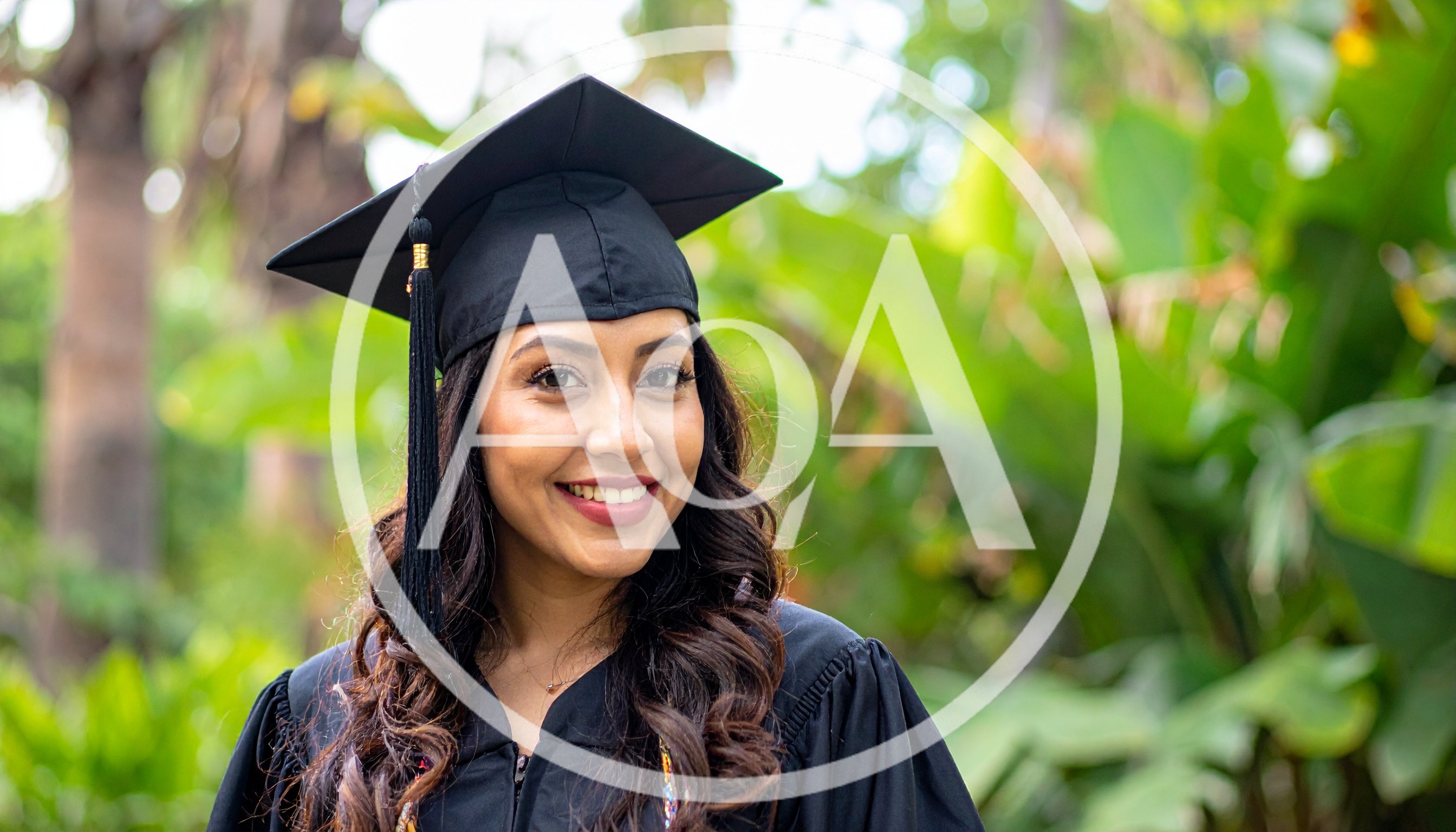 Young Woman Wearing Graduation Cap and Gown Outdoors