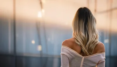 Woman With Blonde Hair Looking Out A Window