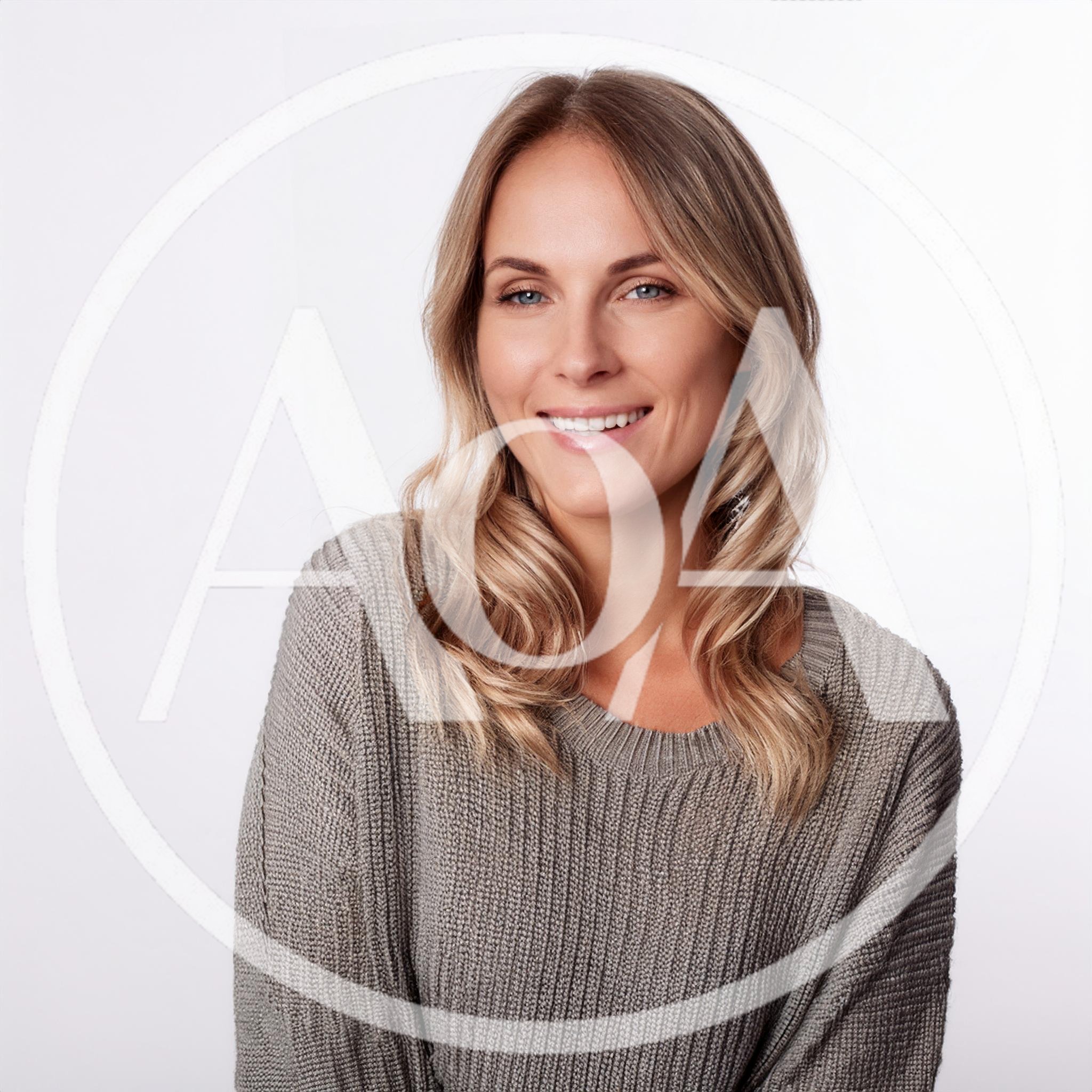 Portrait Of A Smiling Blonde Woman In A Sweater
