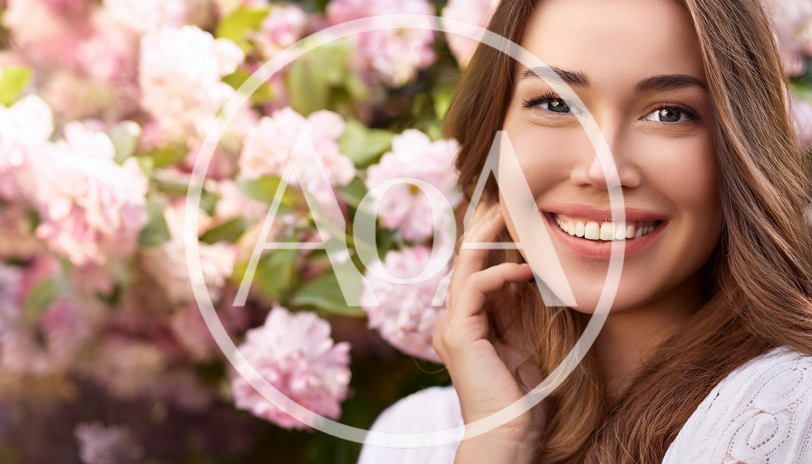 Smiling Young Woman Posing Near Blooming Pink Flowers
